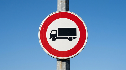 Panneau interdiction camion : disque blanc bordé de rouge avec silhouette de poids lourd sur un poteau