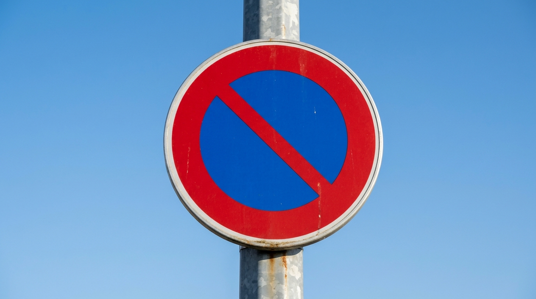 Panneau stationnement interdit : disque bleu bordé de rouge à une diagonale rouge sur un poteau