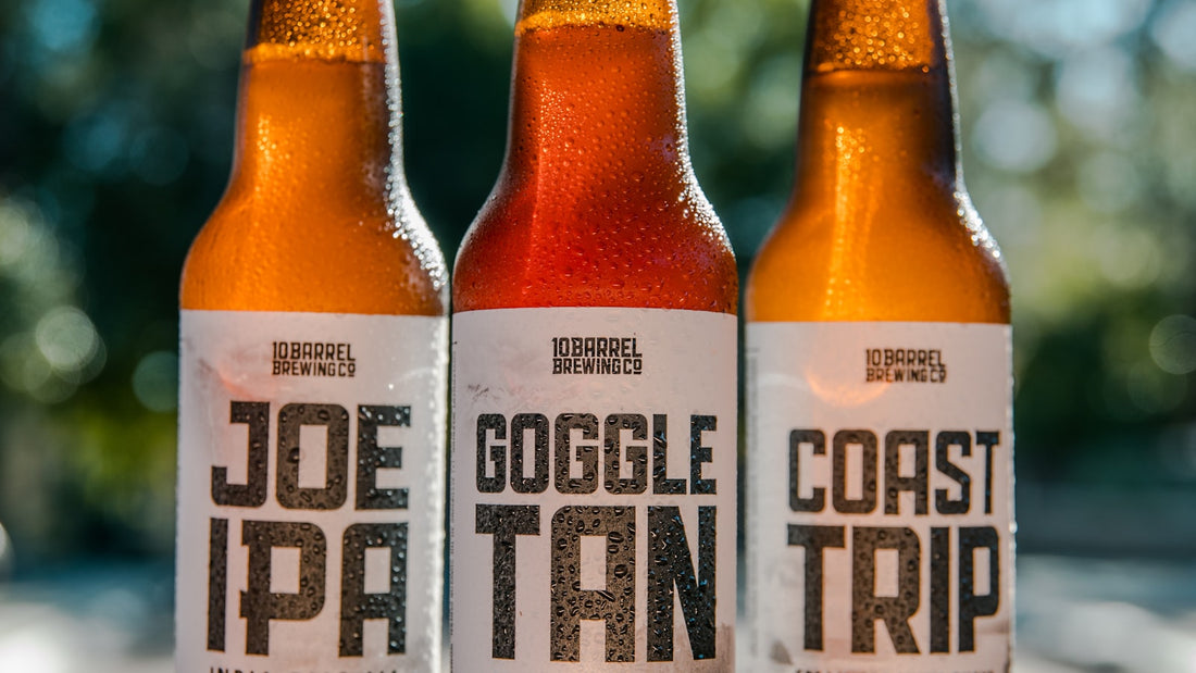 Artisan posant une étiquette adhésive sur une bouteille de bière brassée maison