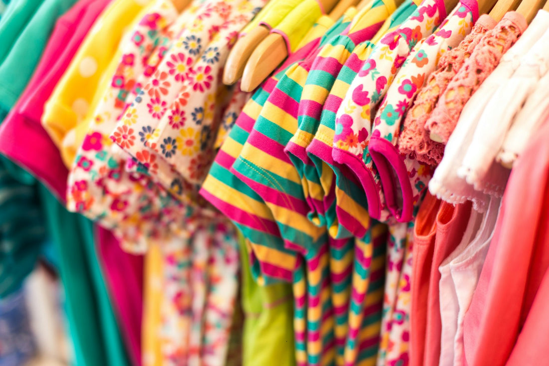 Portant de vêtements d'enfant colorés, prêts à être marqués au prénom