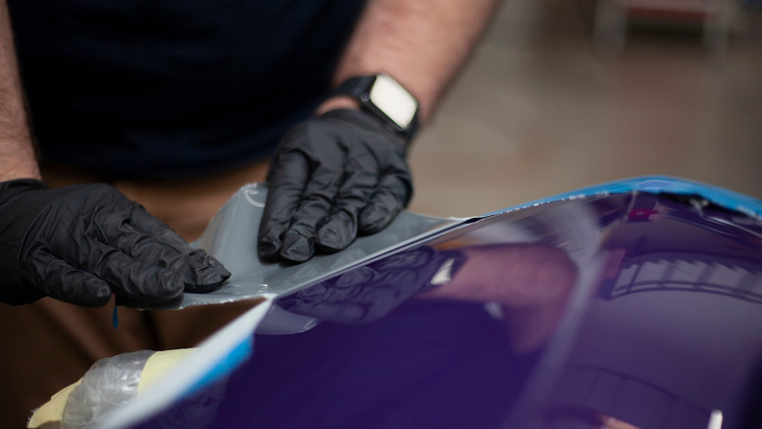 Retrait d'un sticker de carrosserie à la raclette en plastique après chauffe