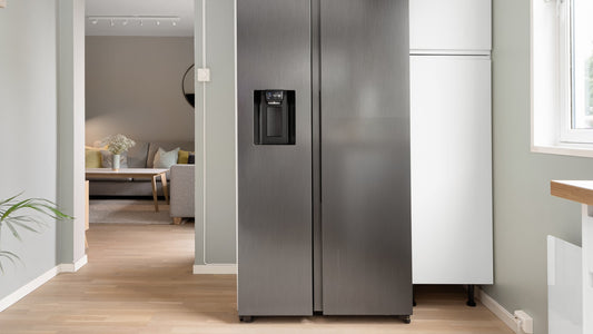 Cuisine moderne avec réfrigérateur en inox, lave-linge et façades lisses bien éclairées