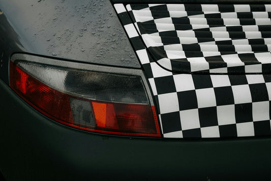 Motif à damier appliqué en autocollant sur la carrosserie arrière d'une voiture, exemple de sticker personnalisé pour voiture.