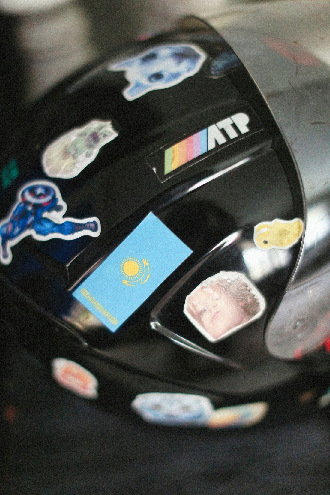 Casque de moto noir couvert d'autocollants variés, illustrant la personnalisation d'un casque de moto avec des autocollants.