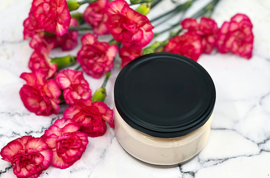 Pot de crème cosmétique posé sur un plan de marbre à côté de fleurs, produit de soin non soumis aux pictogrammes CLP