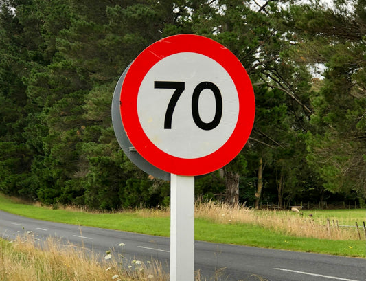 Panneau de limitation de vitesse bien lisible au bord d'une route de campagne