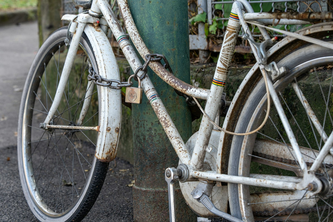 Vélo urbain cadenassé par une chaîne et un cadenas à un poteau dans la rue, contexte du marquage Bicycode contre le vol