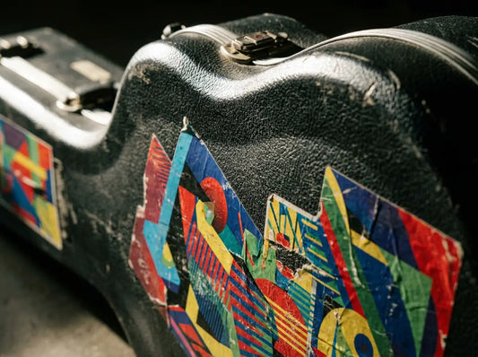 Autocollants aux motifs abstraits sur la coque texturée d'un étui de guitare rigide noir