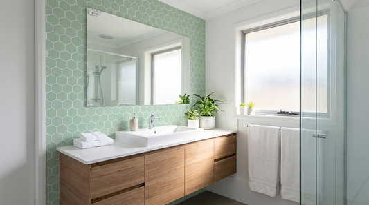 Salle de bain relookée avec des stickers carrelage verts en hexagones autour du miroir et du lavabo